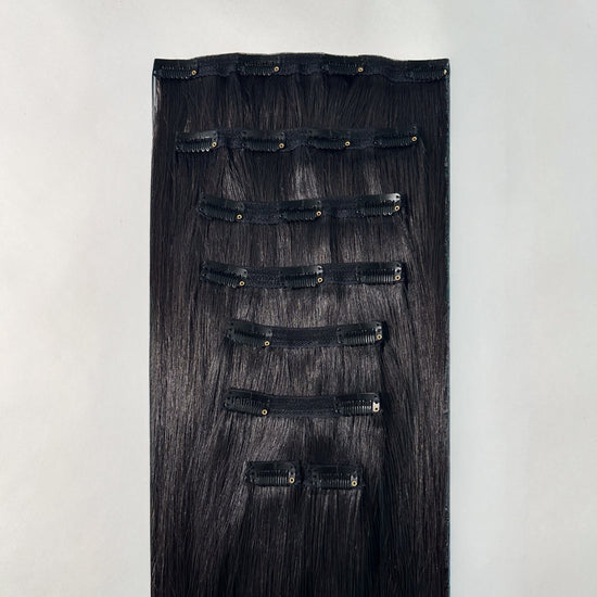 Set of black hair extensions on a white background