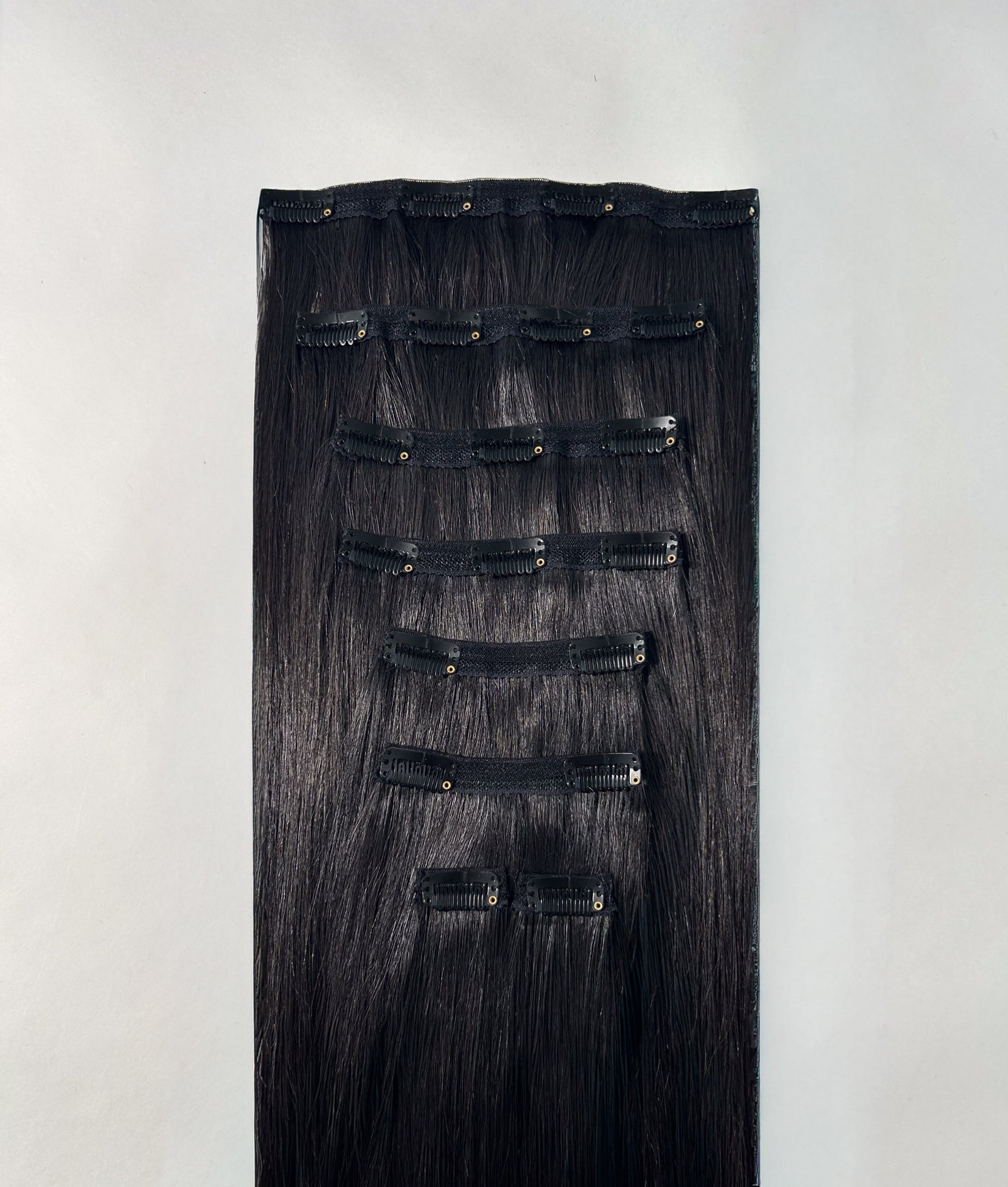 Set of black hair extensions on a white background